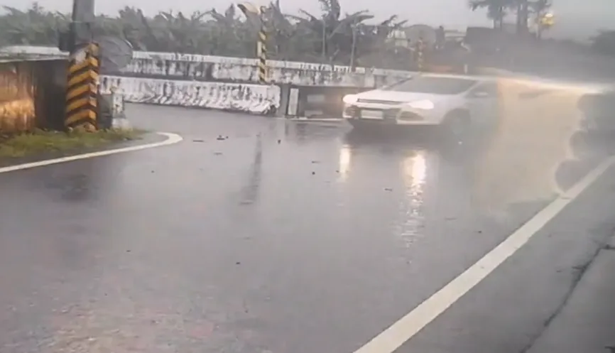 白色休旅車經過塌陷處閃避不及，當場爆胎動彈不得。（圖／翻攝畫面）