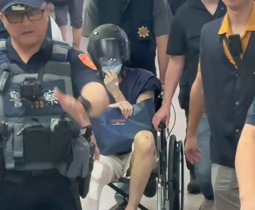 林男24日上午出院後,在10名警力戒護下坐輪椅被帶上車移送新竹地檢署。(圖/中天新聞)