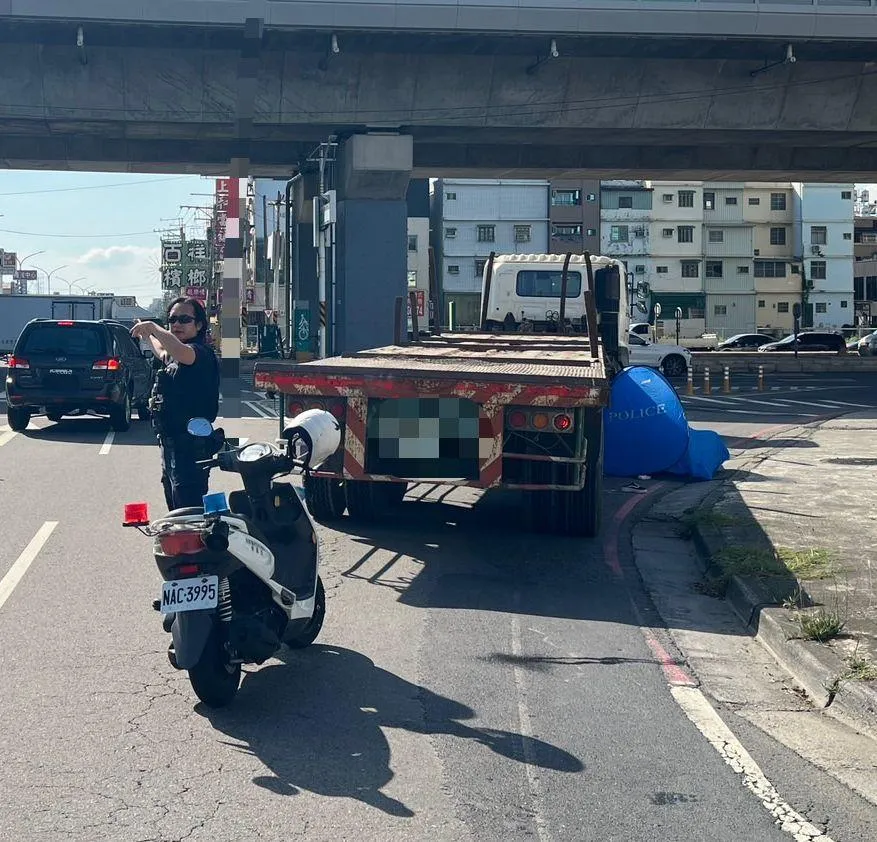 59歲女騎士遭大型拖板車捲入巨輪下方，當場失去生命跡象。（圖／中天新聞）
