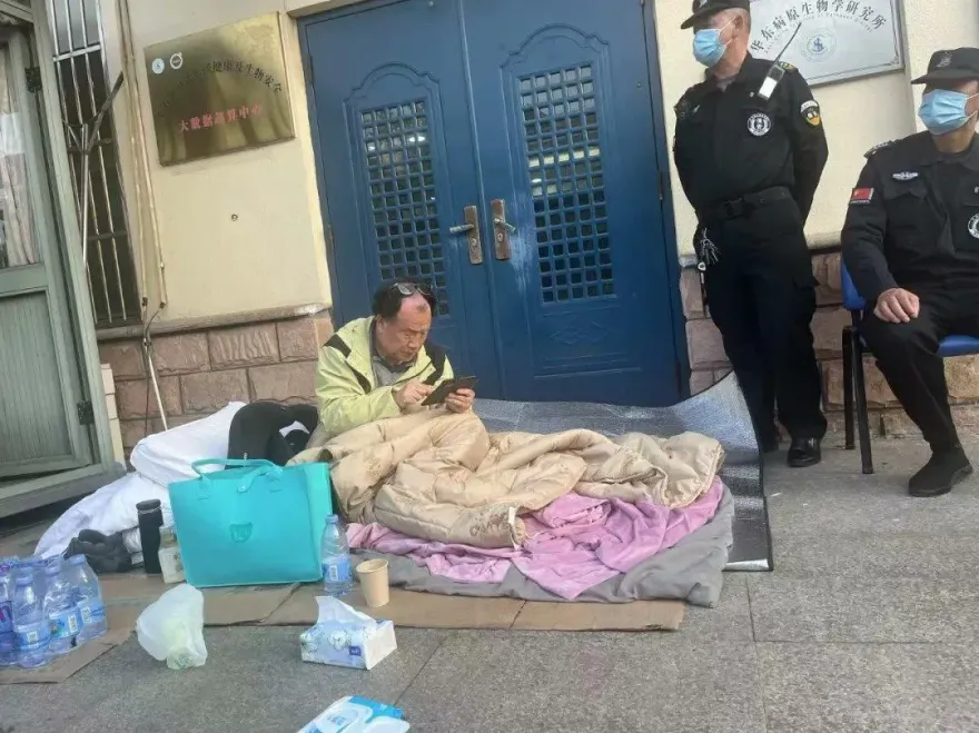 新冠病毒專家冒雨「打地鋪」睡實驗室門口　官方稱係「安全原因」要求其搬離