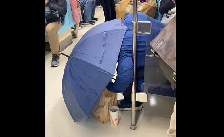 北捷車廂奇景！他餓到「彎腰撐傘嗑麥當勞」　全車看傻