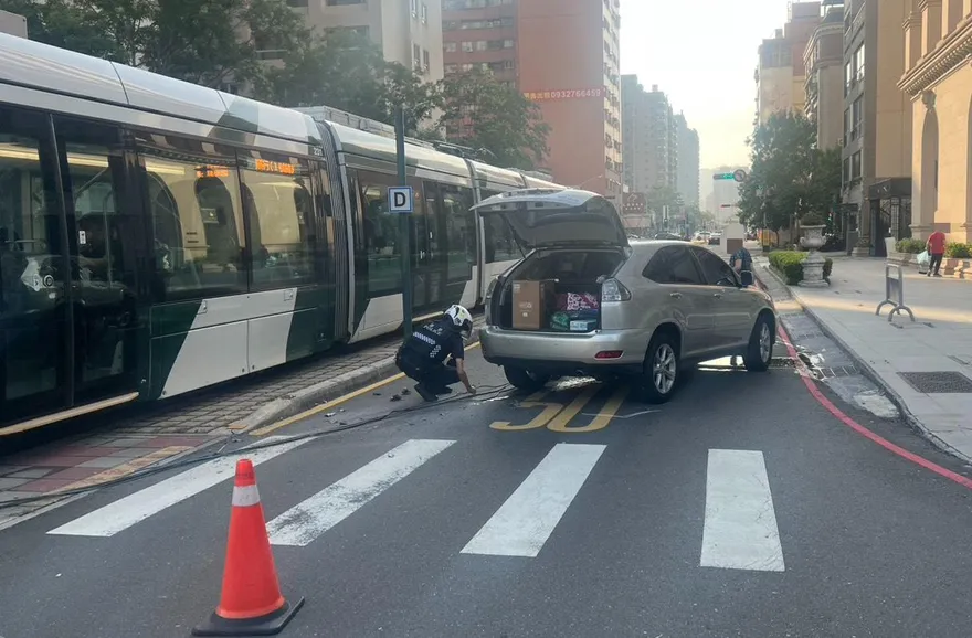 影/即刻救援！高雄駕駛轉彎撞斷輕軌號誌　暖警合力抬轎車