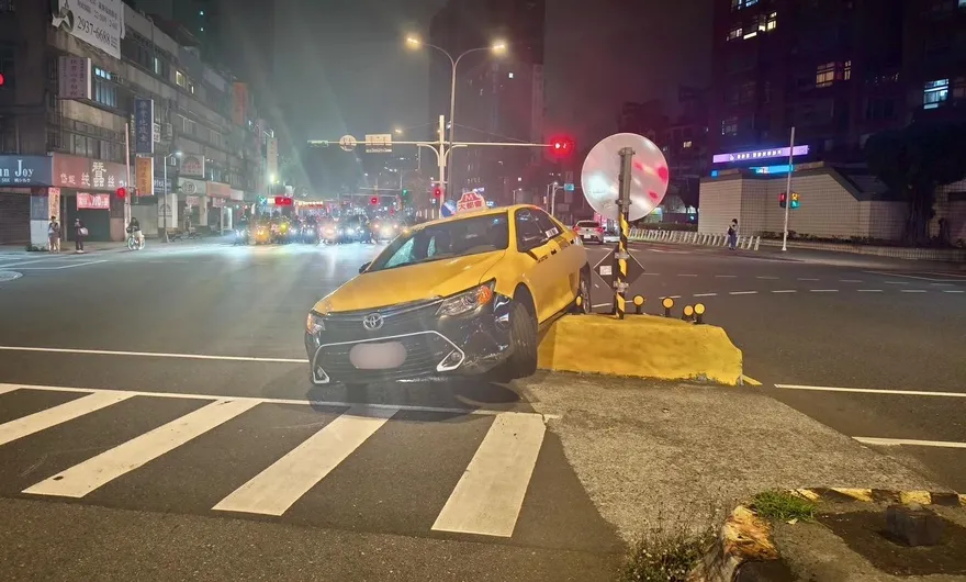 影/北市小黃轉彎騎上庇護島　2輪懸空動彈不得