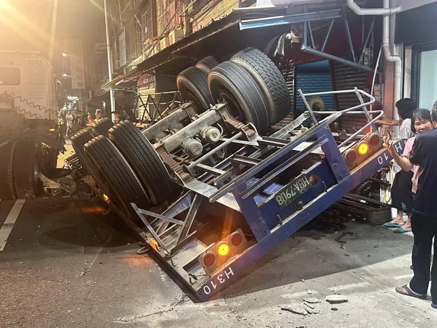 驚魂！雲林拖板車彎道大翻車　巨輪頂屋簷…鋼筋砸4民宅