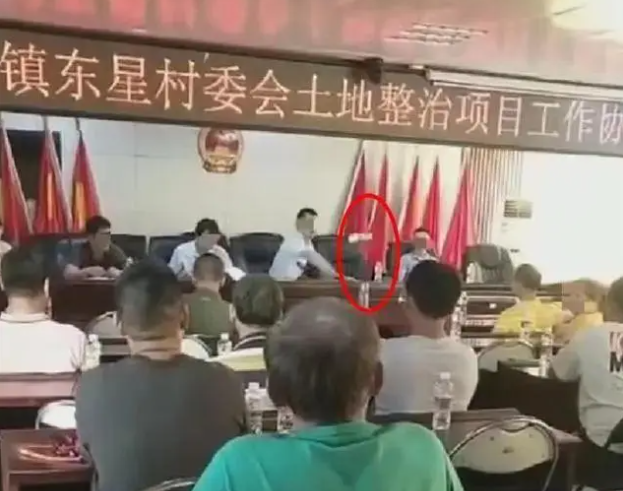 影/講話一直被打斷！海南鎮長疑情緒失控怒扔瓶　村民起身「拍桌對嗆」