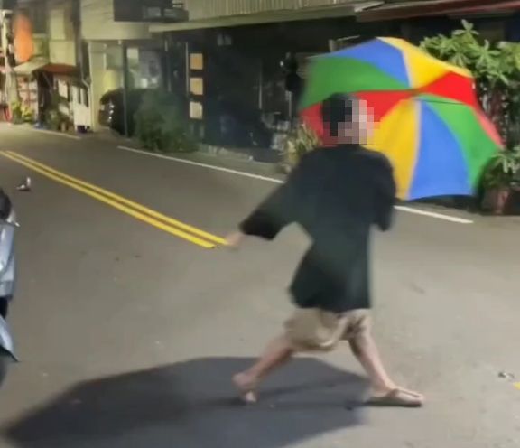 太失禮了！喝茫男撐大花傘街頭亂舞　頭身竟塞入「滾筒洗衣機」