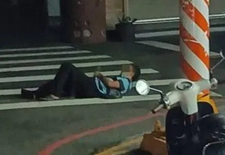 活膩了？詭異大叔深夜躺「斑馬線」上滑手機　網噴：車壓到算誰的