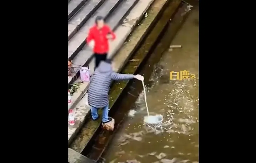 影/這也能放生！2女將「米、麵粉混牛奶」倒江祈福　網友：不到精神科看看？
