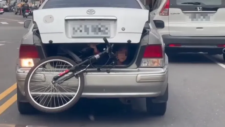 影/有夠扯！讓「孩子躲後車廂」徒手固定腳踏車　誇張爹要挨罰了