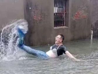 高雄遭凱米風雨侵襲慘變「水樂園」　壯漢苦中作樂變身「大美人魚」猛「甩尾」