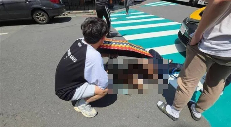 影/又見行人地獄！基隆8旬嬤遭車撞暈　2大學生撐傘陪等救護車