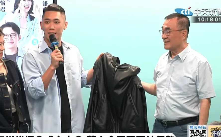 民眾黨新北市議員陳世軒6日代表白營小雞致贈李四川一件黃仁勳的標誌黑皮衣。（圖／中天新聞）