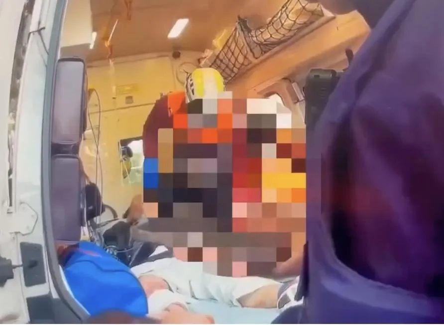 蕭姓董事長小腿血流如注被送上救護車。(圖/翻攝畫面)