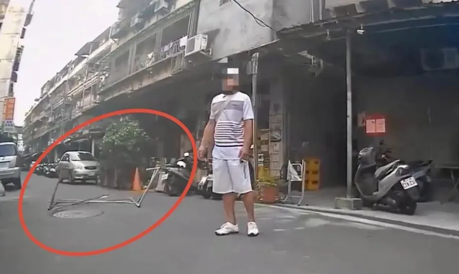 男子喝醉酒在路邊拿鷹架擋路。(圖/翻攝畫面)