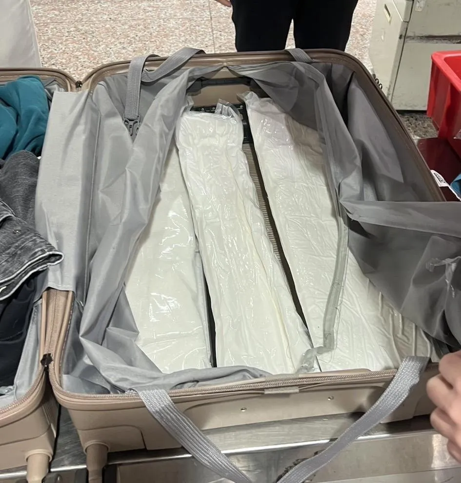 嫌犯將毒品夾藏行李箱內。（圖／翻攝畫面）