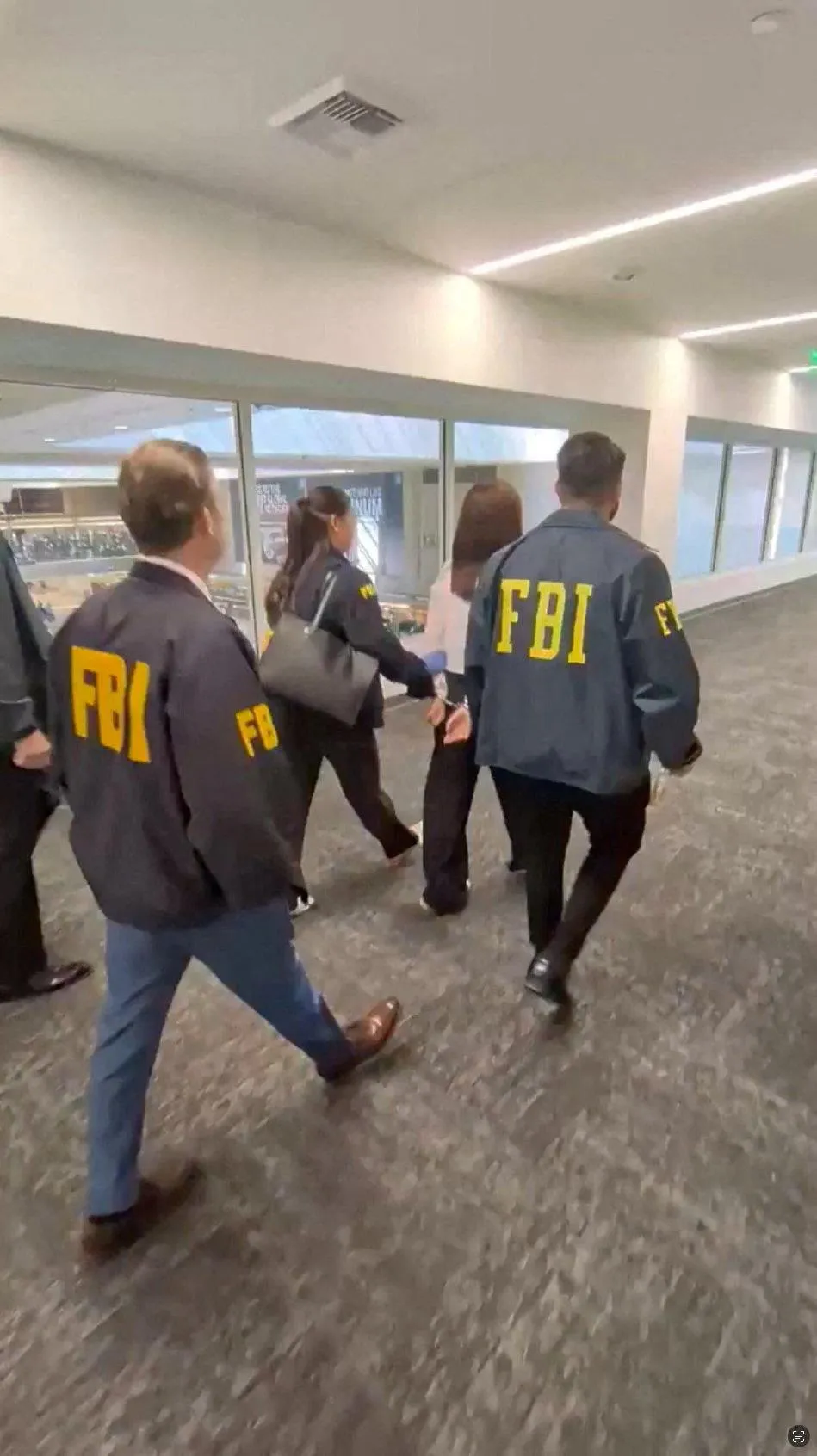 張婉瑩（白衣者）4日被FBI逮捕畫面。（圖／路透社）