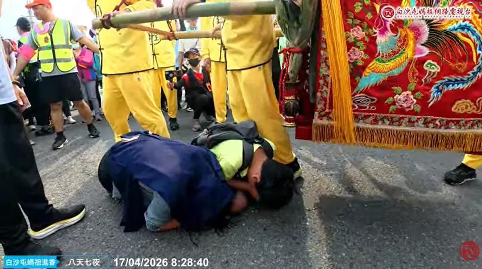 一對母子在鑾轎前跪拜。（圖／翻攝自白沙屯媽祖網路電視台YouTube，下同）