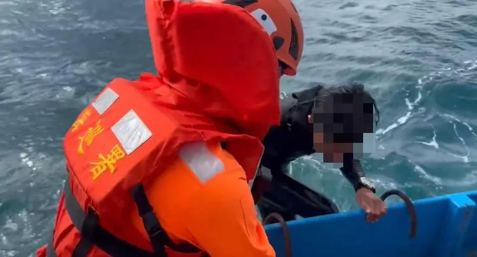 海巡人員將衝浪客救上船。（圖／翻攝畫面）