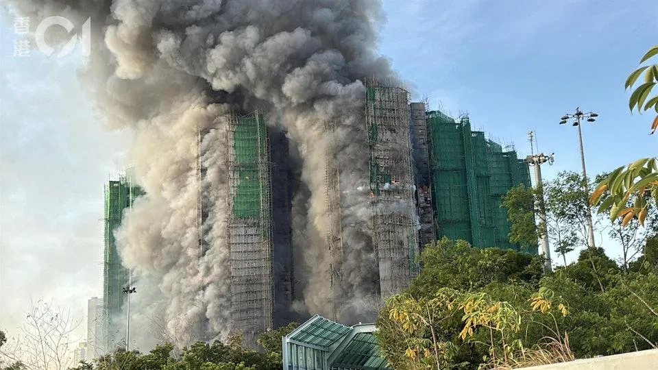 香港大埔地區1處建築物26日下午發生外層棚架起火事件，稍早火場濃煙幾乎遮蔽天空。（圖／香港01）