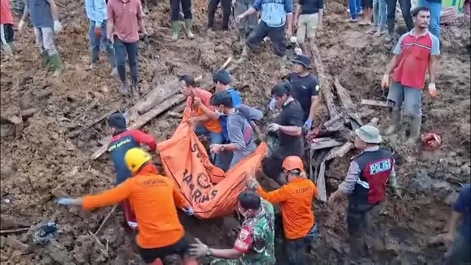 季風豪雨導致印尼北蘇門答臘省洪災，目前當地已有逾270人失蹤，救難人員正在搬運屍袋。（圖／路透社）