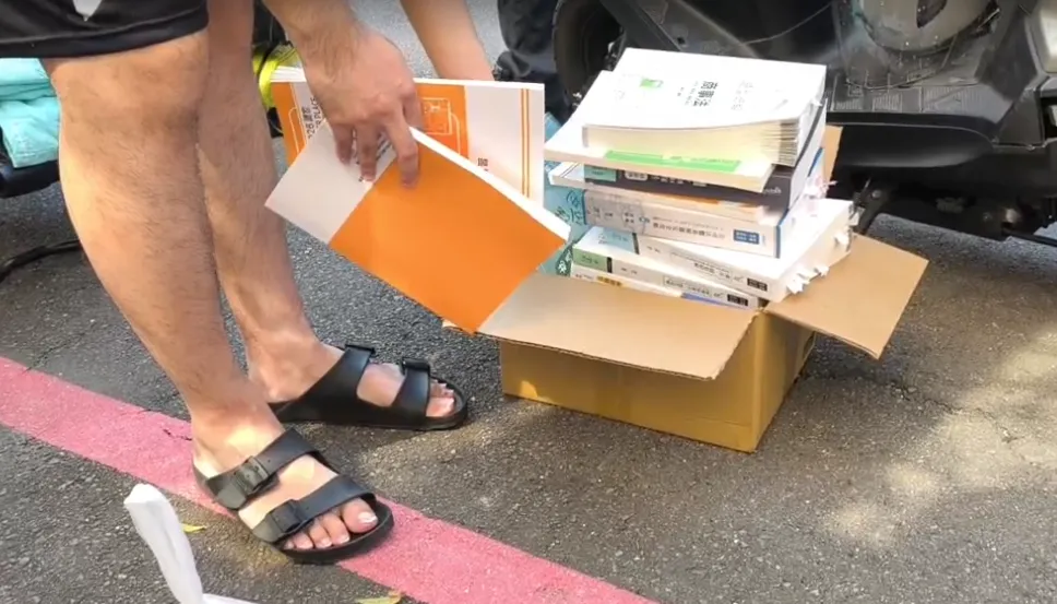 起火民宅隔壁住戶兄弟檔逃命時，弟弟不忘抱著厚重考書衝出去。（圖／中天新聞）