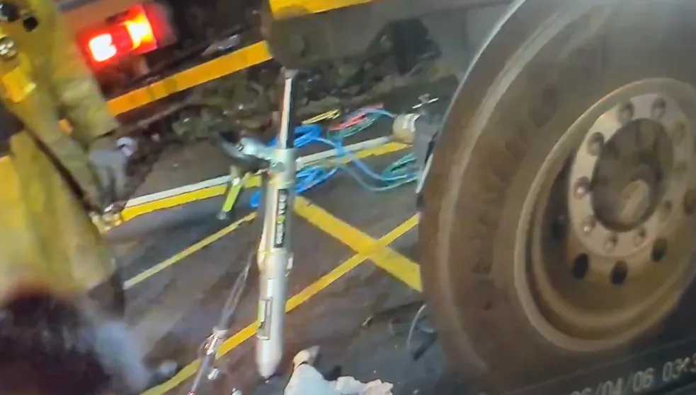 消防員出動重型救援推頂器材，把大貨車頂起後，順利搬出女騎士遺體。（圖／翻攝畫面）
