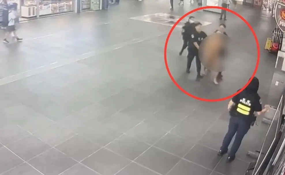 男子在北車大廳一絲不掛遭員警管束帶回。(圖/翻攝畫面)